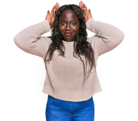 Young african woman wearing wool winter sweater doing bunny ears gesture with hands palms looking cynical and skeptical. easter rabbit concept.
