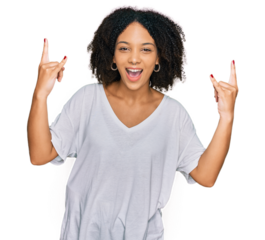 Young african american girl wearing casual clothes shouting with crazy expression doing rock symbol with hands up. music star. heavy concept.