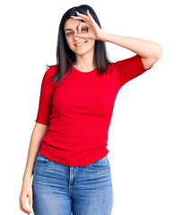 Young beautiful girl wearing casual t shirt smiling happy doing ok sign with hand on eye looking through fingers