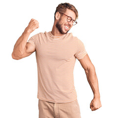Young caucasian man wearing casual clothes and glasses dancing happy and cheerful, smiling moving casual and confident listening to music