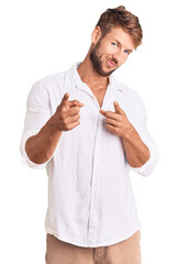 Young caucasian man wearing casual clothes pointing fingers to camera with happy and funny face. good energy and vibes.