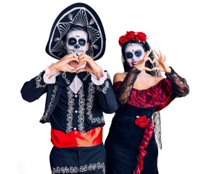 Young couple wearing mexican day of the dead costume over background smiling in love doing heart symbol shape with hands. romantic concept.