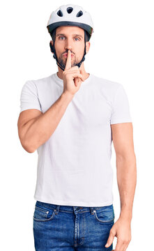 Young handsome man wearing bike helmet asking to be quiet with finger on lips. silence and secret concept.