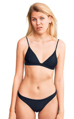 Obraz premium Young beautiful blonde woman wearing bikini skeptic and nervous, frowning upset because of problem. negative person.