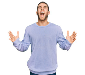 Young caucasian man wearing casual clothes crazy and mad shouting and yelling with aggressive expression and arms raised. frustration concept.