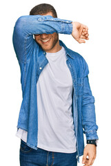 Young caucasian man wearing casual clothes covering eyes with arm smiling cheerful and funny. blind concept.