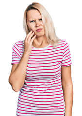 Young caucasian woman wearing casual clothes touching mouth with hand with painful expression because of toothache or dental illness on teeth. dentist