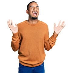 Fototapeta premium Young african american man wearing casual clothes celebrating crazy and amazed for success with arms raised and open eyes screaming excited. winner concept
