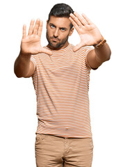 Fototapeta premium Handsome hispanic man wearing casual clothes doing frame using hands palms and fingers, camera perspective