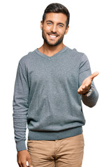 Naklejka premium Handsome hispanic man wearing casual clothes smiling friendly offering handshake as greeting and welcoming. successful business.