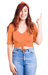 Fototapeta premium Young beautiful woman wearing casual clothes pointing finger up with successful idea. exited and happy. number one.