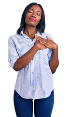 Young african american woman wearing casual clothes smiling with hands on chest with closed eyes and grateful gesture on face. health concept.