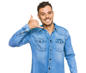 Young hispanic man wearing casual denim jacket smiling doing phone gesture with hand and fingers like talking on the telephone. communicating concepts.