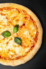 Homemade pizza with cheese and basil leaves