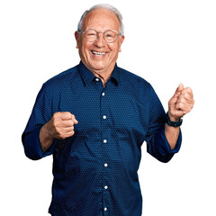 Senior man with grey hair wearing casual shirt and glasses excited for success with arms raised and...