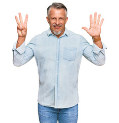 Fototapeta premium Middle age grey-haired man wearing casual clothes showing and pointing up with fingers number eight while smiling confident and happy.