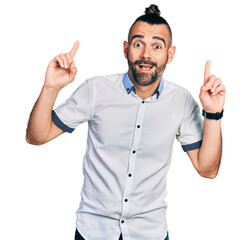 Fototapeta premium Hispanic man with ponytail wearing casual white shirt smiling amazed and surprised and pointing up with fingers and raised arms.