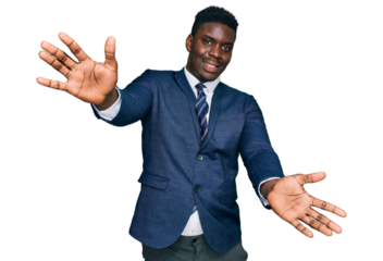Handsome business black man wearing business suit and tie looking at the camera smiling with open arms for hug. cheerful expression embracing happiness.