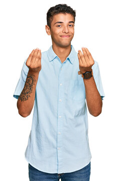 Young handsome african american man wearing casual clothes doing money gesture with hands, asking for salary payment, millionaire business