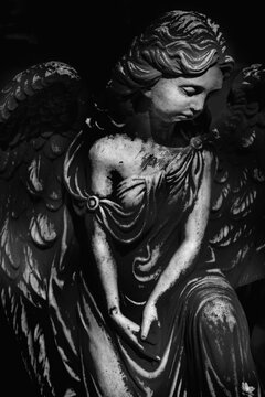 Death. Black and white image of beautiful angel as symbol of pain, fear and end of life. Vertical image.