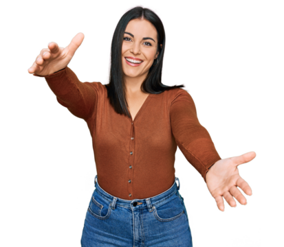 Young hispanic woman wearing casual clothes looking at the camera smiling with open arms for hug. cheerful expression embracing happiness.