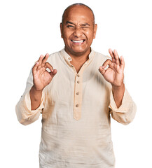 Hispanic middle age man doing ok gesture with hand winking looking at the camera with sexy...