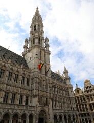 Fototapeta na wymiar Brussels town hall and the belgian flag in Grand Place