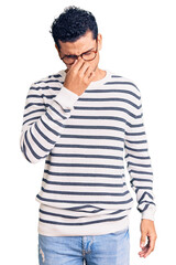 Hispanic handsome young man wearing casual clothes and glasses tired rubbing nose and eyes feeling fatigue and headache. stress and frustration concept.