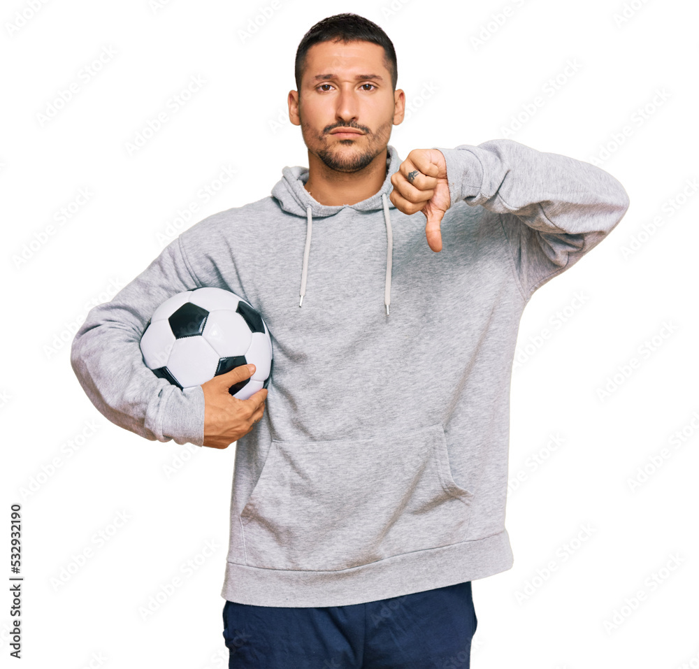 Sticker handsome man with tattoos holding soccer ball with angry face, negative sign showing dislike with th