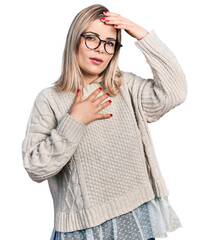 Young blonde woman wearing glasses touching forehead for illness and fever, flu and cold, virus sick