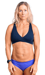 Fototapeta premium Middle age fit blonde woman wearing bikini depressed and worry for distress, crying angry and afraid. sad expression.