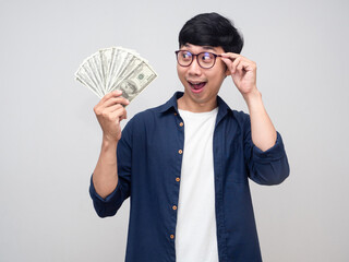 Positive asian man wear glasses cheerful looking at a lot of money in hand