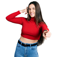 Young brunette teenager wearing red turtleneck sweater smiling doing talking on the telephone...