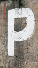 Letra P pintada con pintura blanca en pared de hormigón