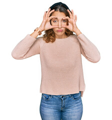 Beautiful young caucasian woman wearing casual sweater trying to open eyes with fingers, sleepy and tired for morning fatigue