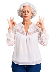 Senior grey-haired woman wearing casual clothes relax and smiling with eyes closed doing meditation gesture with fingers. yoga concept.