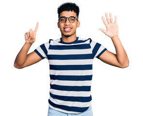 Naklejka premium Young african american man wearing casual clothes and glasses showing and pointing up with fingers number six while smiling confident and happy.