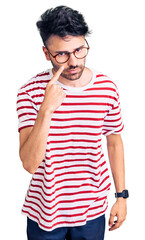 Young hispanic man wearing casual clothes pointing to the eye watching you gesture, suspicious expression