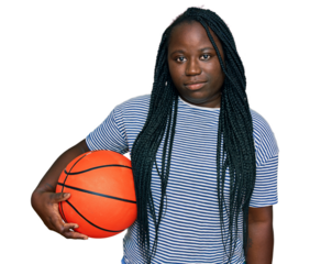 Young black woman with braids holding basketball ball thinking attitude and sober expression looking self confident