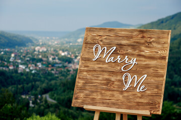 A romantic location in the mountains for a proposal of the hand and the heart Wooden easel with the...