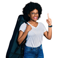 Young african american woman wearing guitar case smiling with an idea or question pointing finger...
