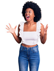 Young african american woman wearing casual clothes crazy and mad shouting and yelling with aggressive expression and arms raised. frustration concept.