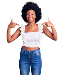 Young african american woman wearing casual clothes looking confident with smile on face, pointing oneself with fingers proud and happy.