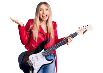 Young beautiful blonde woman playing electric guitar celebrating victory with happy smile and winner expression with raised hands