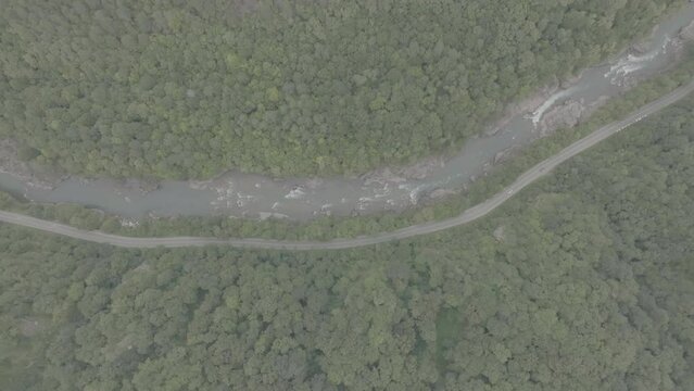 Aerial view of Mountain river and road. Flying over a mountain gorge. ProRes 422, 10 bit ungraded DJI D-LOG video