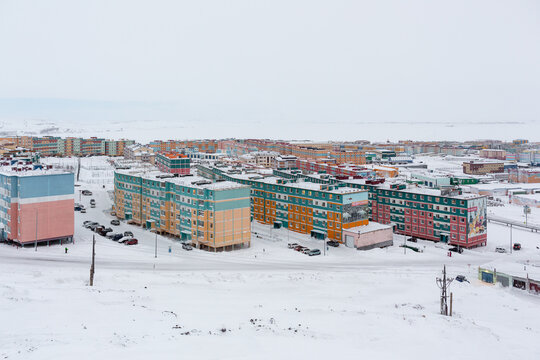 Winter top view of a snow-covered northern city in the Arctic. On colorful buildings there are billboards with the text &ldquo;We live here!&rdquo;, &ldquo;We are growing!&rdquo;. Anadyr, Chukotka, Russia.