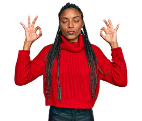 African american woman wearing casual winter sweater relax and smiling with eyes closed doing meditation gesture with fingers. yoga concept.