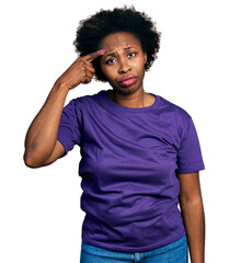 Fototapeta na wymiar African american woman with afro hair wearing casual purple t shirt pointing unhappy to pimple on forehead, ugly infection of blackhead. acne and skin problem