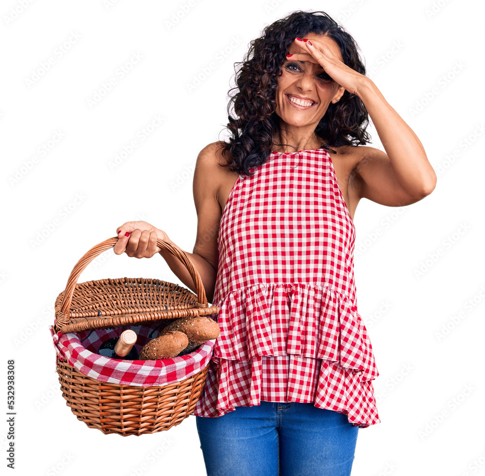 Wall mural middle age beautiful woman holding picnic basket with food stressed and frustrated with hand on head