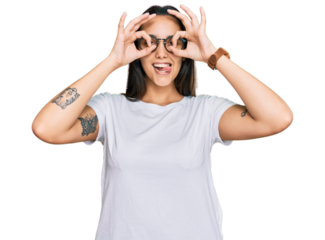 Young hispanic woman wearing casual white t shirt doing ok gesture like binoculars sticking tongue out, eyes looking through fingers. crazy expression.
